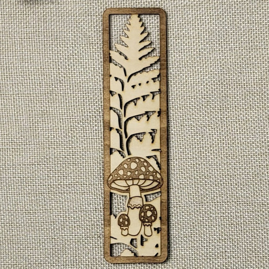 Wooden bookmark with mushroom design on a textured fabric background