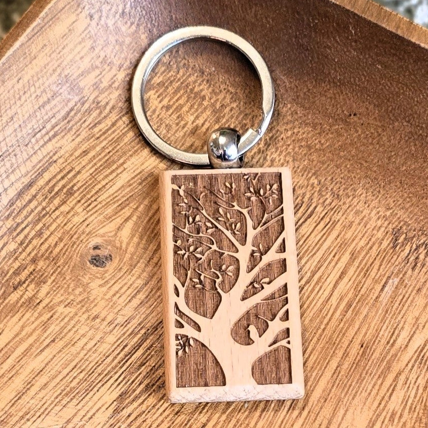 Wooden keychain with tree design on a wooden tray