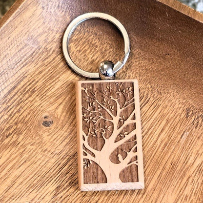 Wooden keychain with tree design on a wooden tray